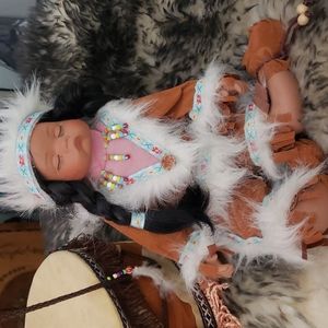Indian baby doll sitting on drum.